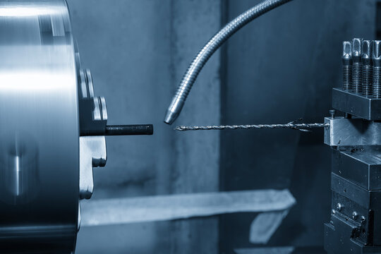 High-precision turning machine performing a small hole making process on a non-ferrous material part.