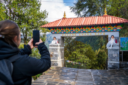 Mujer senderista tomando una foto a la entrada pasang lhamu, iniciando su recorrido al campamento base del everest.