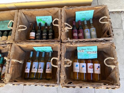 Portuguese red, white and ros&eacute; souvenir local wine bottles in market crates, Carvoeiro, Algarve, Portugal 31 March 2026
