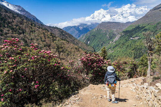Mujer senderista caminando por los espectaculares caminos del valle khumbu. Yendo al Everest Base Camp, en Nepal.