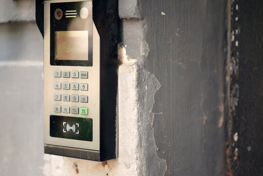 Modern outdoor smart intercom access panel with video camera, PIN keypad, and RFID contactless reader mounted at building entrance.