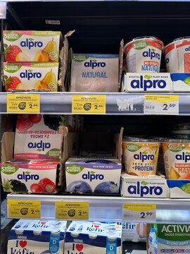 Alpro plant-based soy yogurt, skyr-style cups and fruit dessert multipacks displayed with Portuguese promotional price labels on a refrigerated supermarket shelf, 2 April 2026, Lissabon, Portugal