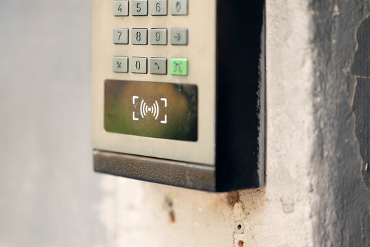 Modern outdoor smart intercom access panel with video camera, PIN keypad, and RFID contactless reader mounted at building entrance.