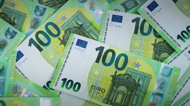 Macro close-up of many 100 euro notes focusing on fine details, security elements and texture, illustrating wealth and cash money concept. 4K Video.