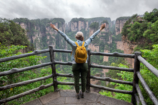 Young female tourist enjoying beautiful nature landscape with mist at Tianmen Shan national park, The famous tourist destination at Zhangjiajie