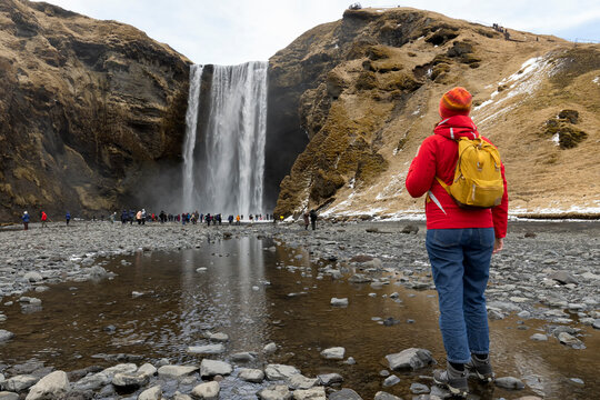 Happy tourist traveler woman enjoying on Skogafoss waterfall in Iceland, Europe travel vacation