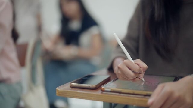 Close-up of a student interacting with a tablet and stylus in a classroom environment. Suitable for smart education, digital transformation, interactive learning, classroom technology, and academic in