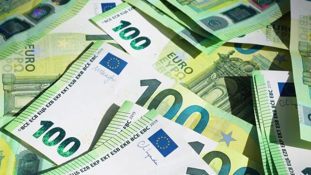 Macro close-up of many 100 euro notes focusing on fine details, security elements and texture, illustrating wealth and cash money concept. 4K Video.