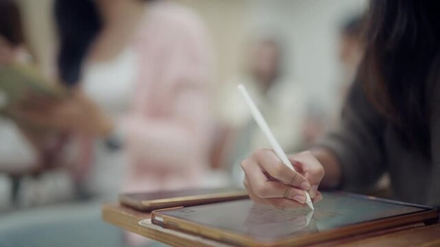 Student using a digital tablet and stylus to write notes during a classroom lecture. Ideal for modern education, paperless learning, educational technology, online resources, and digital productivity 