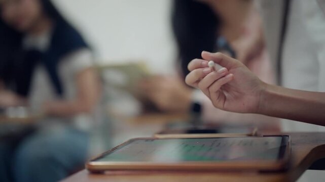 Close-up of a university student writing on a tablet with a stylus during class. Suitable for digital education, higher education, smart learning, note-taking, educational technology, and academic suc