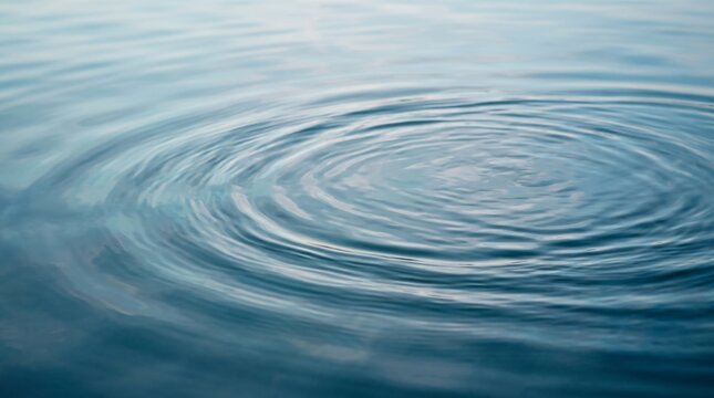 Concentric ripples spreading across calm dark blue water surface with abstract background tranquility rippling reflection