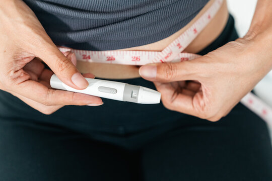 Woman injecting a weight loss pen into her abdomen for diet control. Concept of obesity treatment, GLP-1 medication and slim body goals.