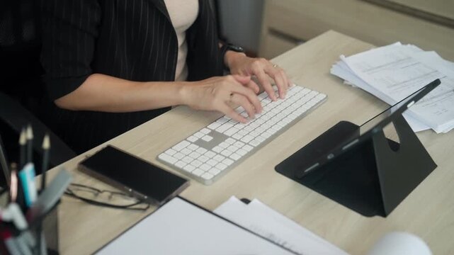 Top view of a business professional typing on a computer keyboard at an organized office desk. Ideal for office work, administration, productivity, corporate communication, remote collaboration, digit