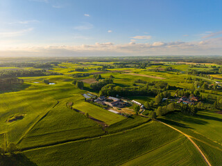 Wide drone panorama of patchwork agricultural fields in Barkoczyn, Pomerania, showcasing the rolling Polish countryside in soft golden light. © Lukasz