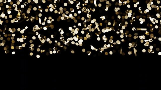 Shiny gold glitter particles cascading down during a celebratory event