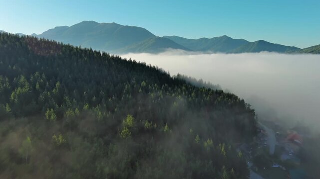 Aerial foggy mountain landscape with clear sky. Morning mist covering forest and hills, 4k