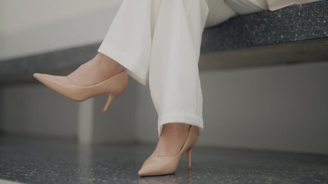 Close-up of a professional businesswoman wearing elegant high heels while sitting in a modern office. Ideal for business fashion, executive lifestyle, corporate professionalism, workplace confidence, 
