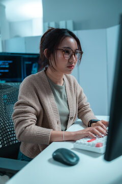 Software developer working on desktop computer in office, analyzing code and building digital solutions, representing programming, software engineering, technology, productivity, innovation.
