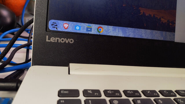 ITABIRA, BRAZIL - JULY 23, 2026: Close-up of a Lenovo laptop screen displaying the Zorin OS Linux taskbar and system icons.
