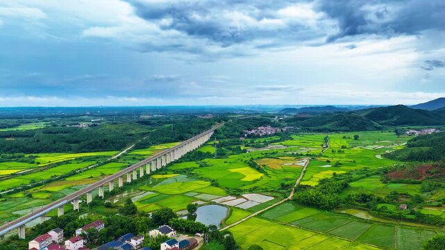 High speed railway viaduct stretching across lush green rice paddy fields and countryside landscape in Guilin, Guangxi, China.