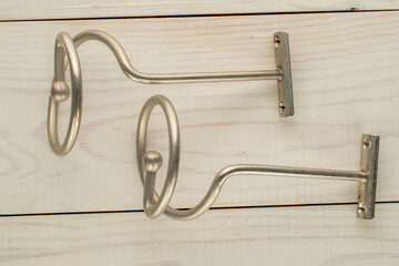 Metal curtain rod Spiral in satin nickel color on a wooden table, close-up. © Oleksandr