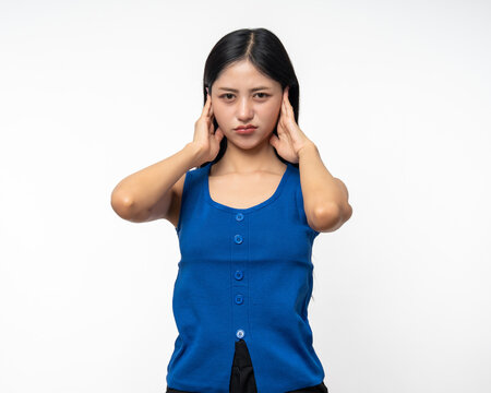 Young Woman stressed and frustrated covering her ears with her hands due to loud noise. Annoyed noise sound pollution. Asian Woman blocking ears