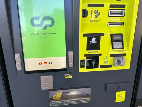 Automated railway comboios de portugal ticket machine finalizing a passenger request, with touchscreen, card terminal, ticket outlet and accessible controls, 5 April 2026, Porto, Portugal