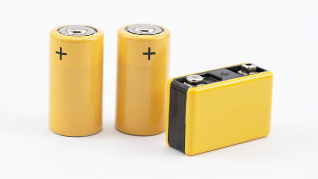 Two cylindrical yellow batteries and a rectangular yellow battery with black top