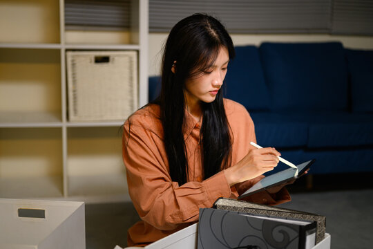Young Asian Gen Z Business Woman Writing on Digital Tablet with Stylus at Home Office