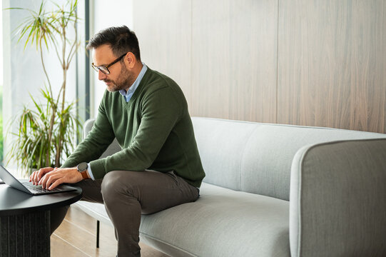 Entrepreneur staying productive and focused, working on laptop in a modern environment, managing business and communicating with remote team