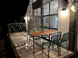 Fotobehang Horeca Modern Outdoor Café Terrace at Night with Wooden Table and Metal Chairs.  © Irfan