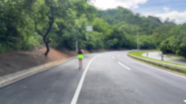 Young woman running on countryside road surrounded by trees