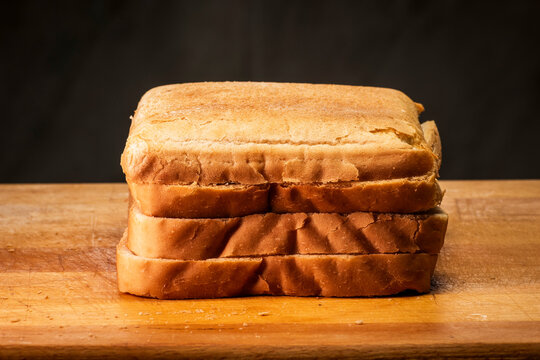 White bread in brown cut table. Slices of food warm light