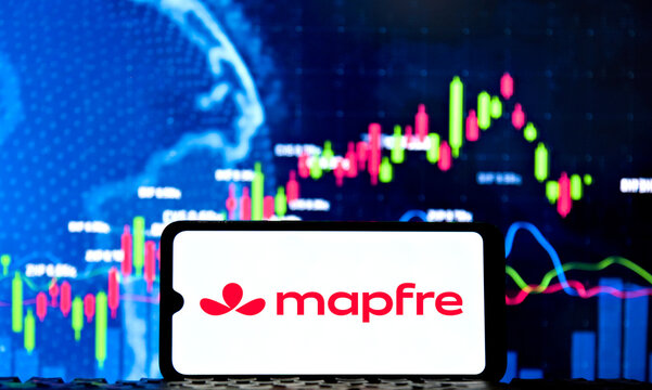 Smartphone displaying the Mapfre logo with financial charts and stock market data on the background screen