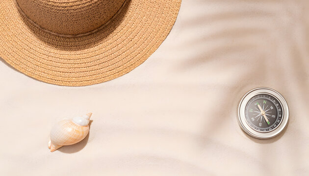 World Tourism Day flat lay with a sun hat, seashell, and compass on sandy beach background