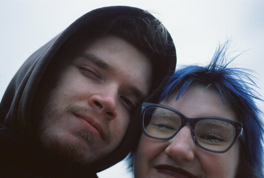 Two friends lean in with easy smiles on film