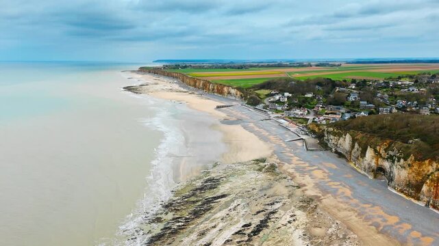 Aerial view of Veules les Roses beside wide beach and Normandy chalk cliffs. English Channel coastal village with farmland and seaside landscape