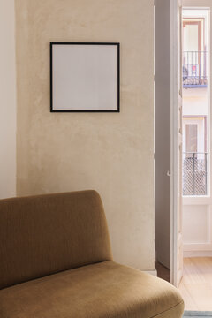 Living room wall with black-framed art print and balcony