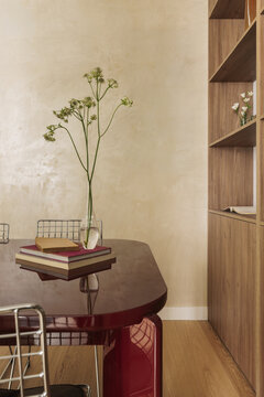 Dining table corner with dried plant stem and stacked books