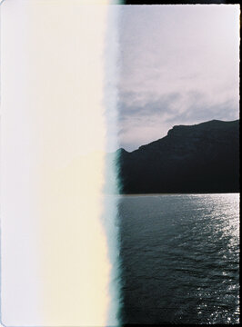 Landscape with abstract light leak on water and mountain