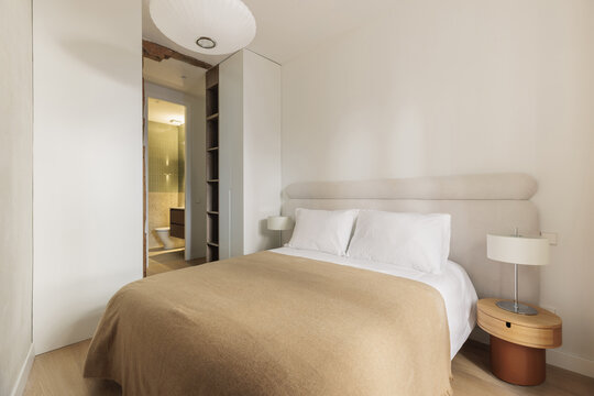 Full bedroom view with antique timber beam and en-suite door