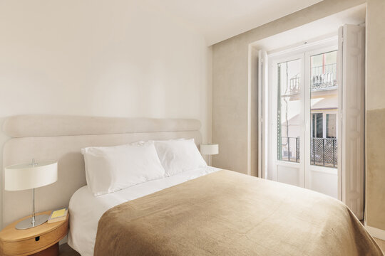Bedroom balcony doors open to Madrid ironwork facade