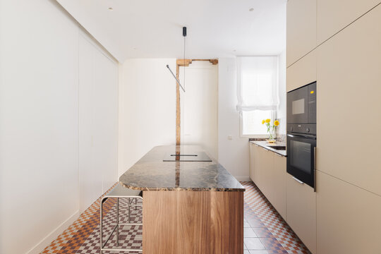 Kitchen island profile with brown marble edge and timber beam