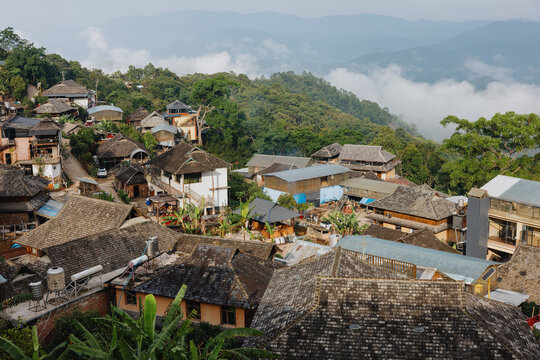 Mountain Village with Traditional Rooftops Above Forest Valley