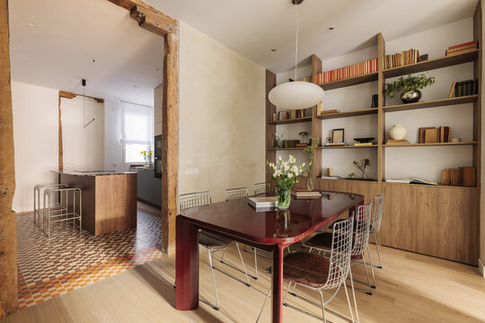 Dining room opening to kitchen through timber beam arch