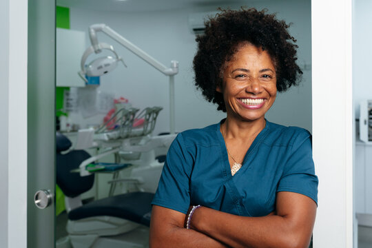 Dentist Smiling at Clinic Doorway