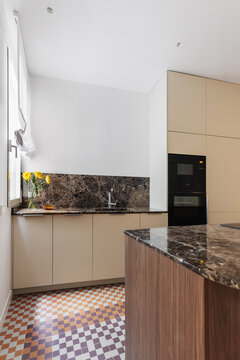 Kitchen portrait with marble backsplash and island foreground