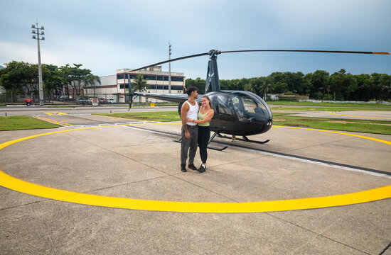 Couple standing beside a helicopter in Brazil