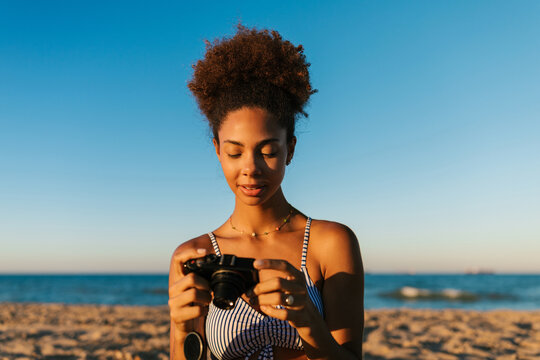 Woman enjoying beach vacation reviewing camera pictures