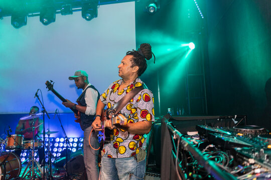 Band performing live music on stage with green lights
